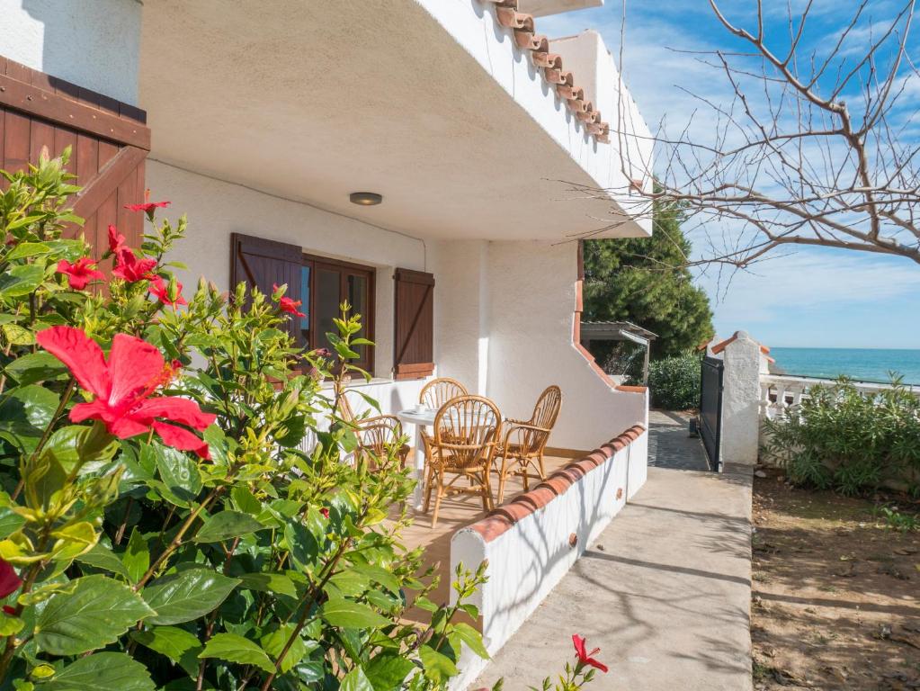 a balcony of a house with chairs and flowers at Casas Pareadas Romana in Alcossebre