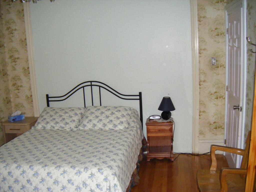 a bedroom with a bed and a lamp on a table at Auberge des Arts Bed and Breakfast in Ottawa