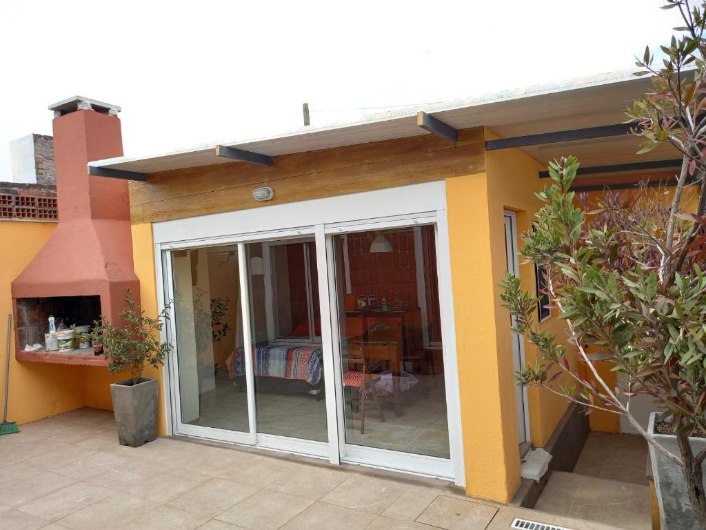 a house with a sliding glass door with a table at Monoambiente en Colonia in Colonia del Sacramento