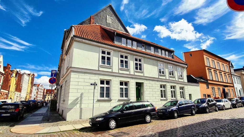 un bâtiment avec des voitures garées devant lui dans une rue dans l'établissement Altstadtfreude Stralsund, à Stralsund