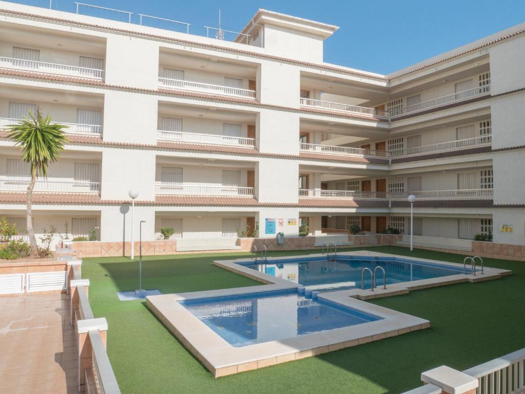 an apartment building with a swimming pool in front of it at Apartamentos Irta Playa in Alcossebre