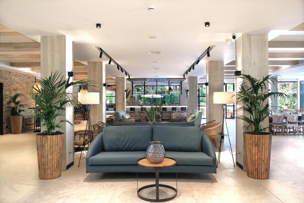 a lobby with a blue couch and a table at Hotel Acapulco in Lloret de Mar