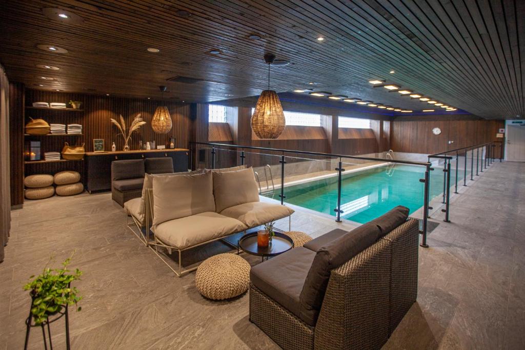 a pool room with couches and a swimming pool at Laponia Hotell & Konferens in Arvidsjaur