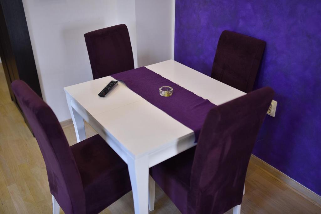 a white table with purple chairs and a ring on it at Apartman Grk 5 in Zlatibor