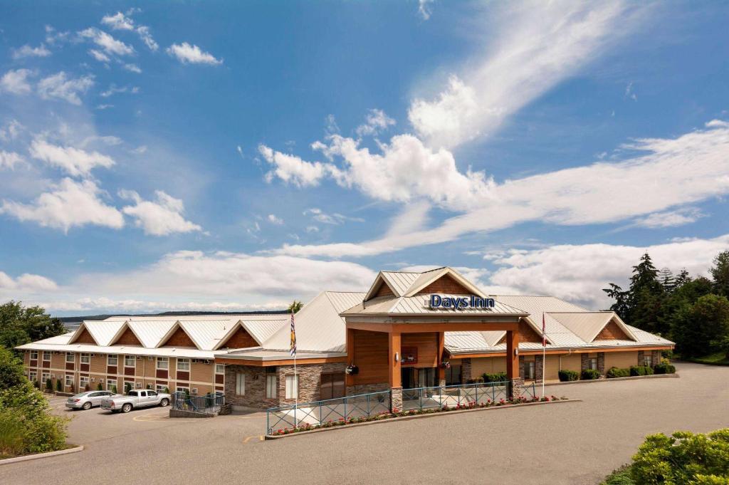a hotel front view of a building with a parking lot at Days Inn by Wyndham Nanaimo in Nanaimo