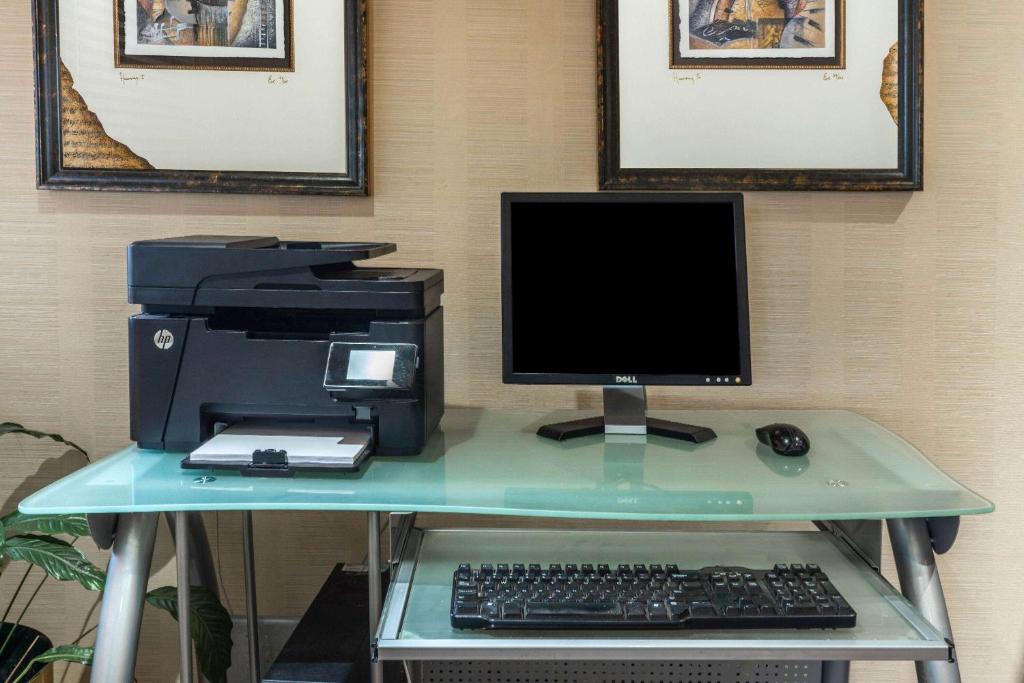 a desk with a computer and a printer on it at Ramada by Wyndham Coquitlam in Coquitlam