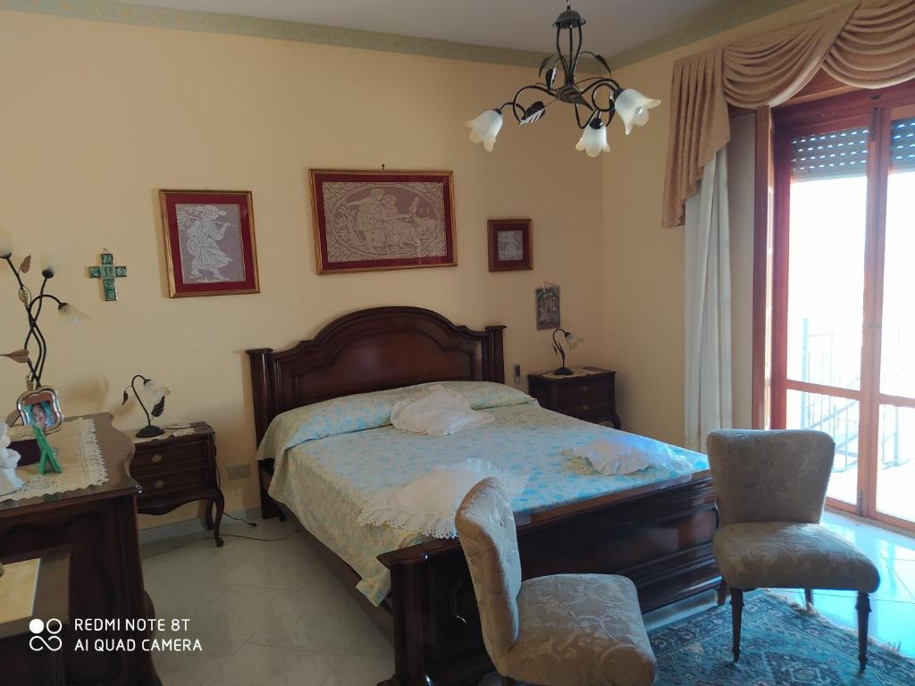 een slaapkamer met een bed, een bureau en een stoel bij Casa vacanze a Serra Scirocco in Trabia