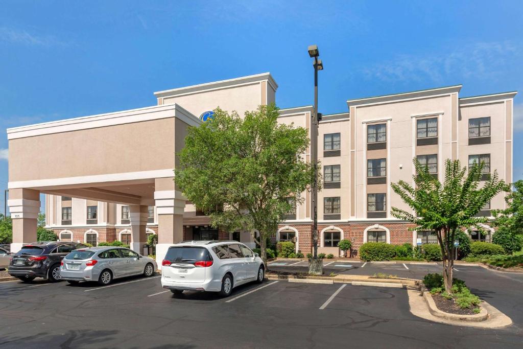 Un edificio de oficinas con coches aparcados en un estacionamiento. en Comfort Suites Southaven - Memphis South, en Southaven