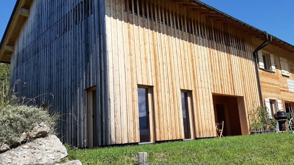 ein großes Holzgebäude mit seitlichen Fenstern in der Unterkunft Ferienwohnung Schönenbühl in Hittisau