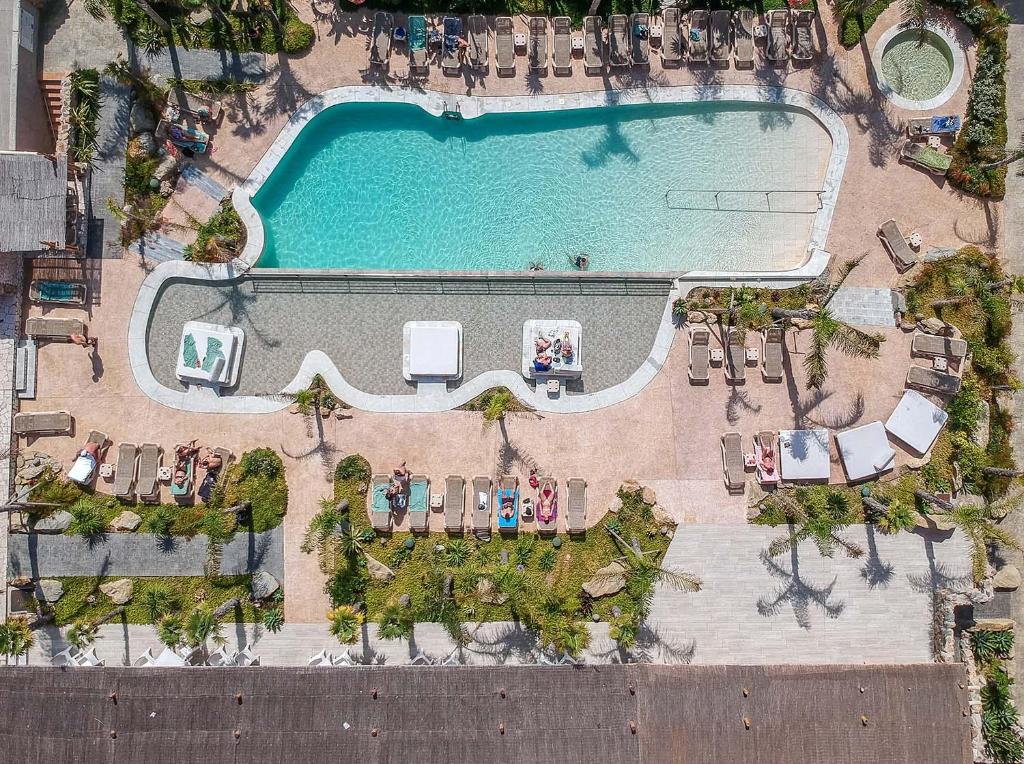 an overhead view of a pool with tables and chairs at Tarifa Lances by QHotels in Tarifa