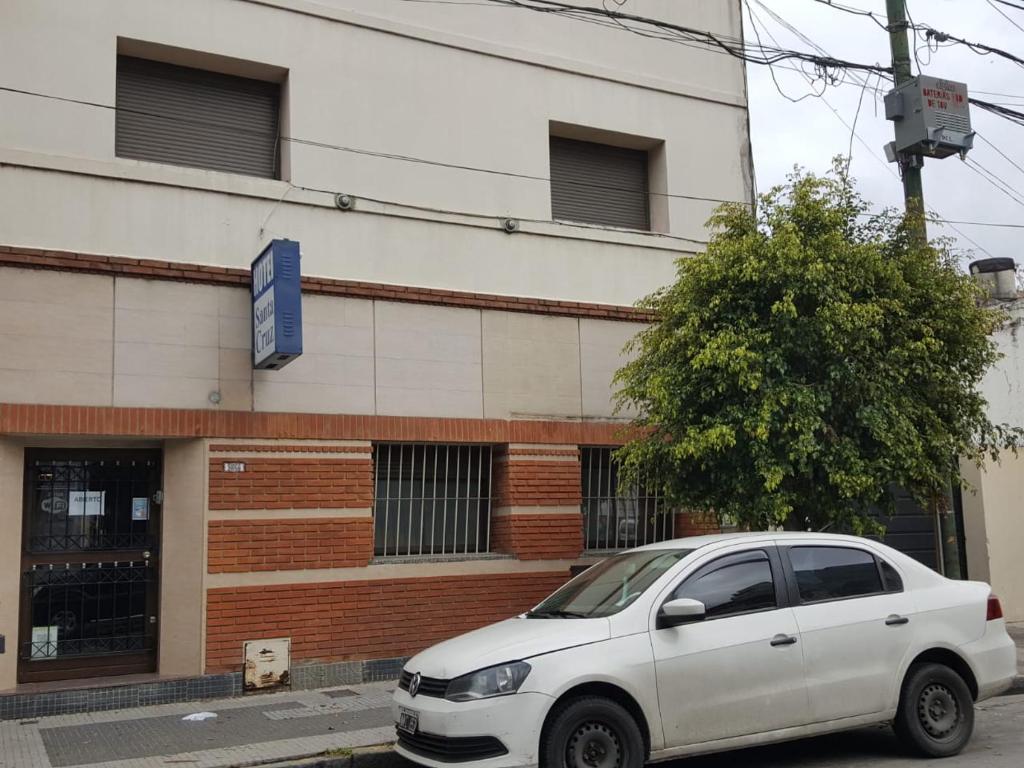 une voiture blanche garée devant un bâtiment dans l'établissement Hotel Santa Cruz, à Buenos Aires