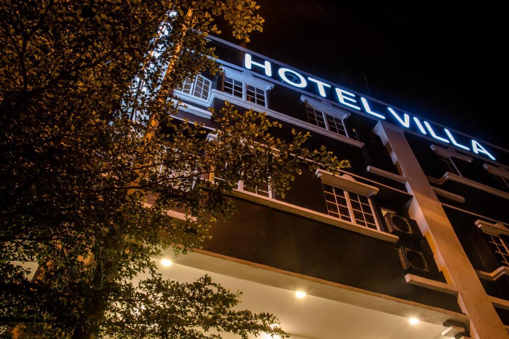 un edificio con un cartel de hotel por la noche en Hotel Villa en Seremban