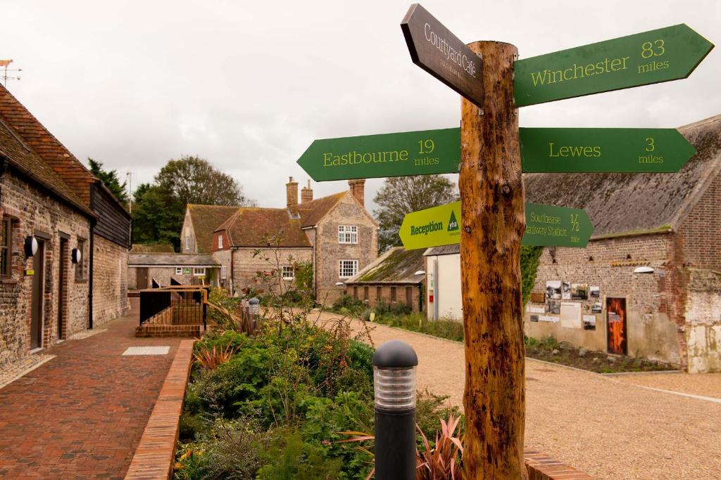 um poste com placas de rua em uma aldeia em YHA South Downs em Lewes