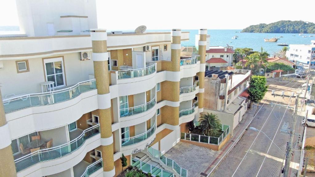 ein Apartmenthaus mit Balkonen und dem Meer im Hintergrund in der Unterkunft Residencial Frederico in Bombinhas