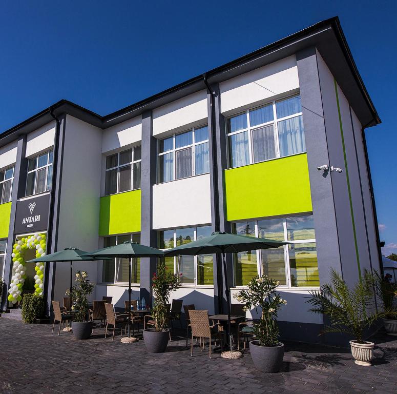 un bâtiment avec des tables et des parasols devant lui dans l'établissement Antari, à Slatina