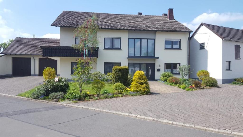 a large white house with a driveway at Ferienwohnung Christina in Hinterweiler