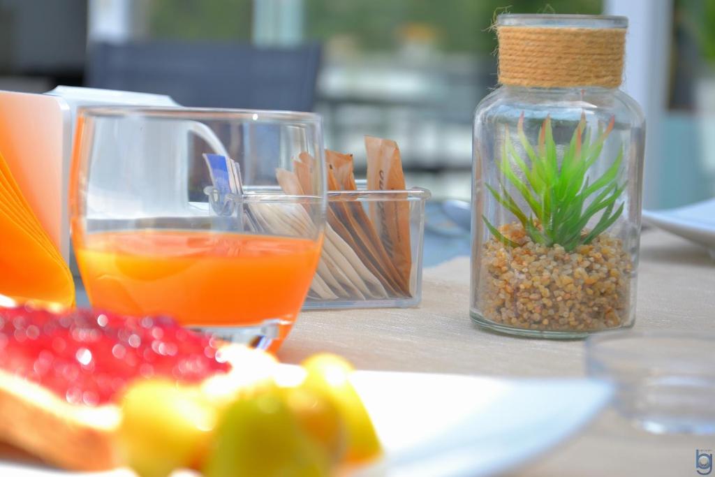 a table with a plate of food and a bottle of orange juice at B&b Mondello Resort in Palermo
