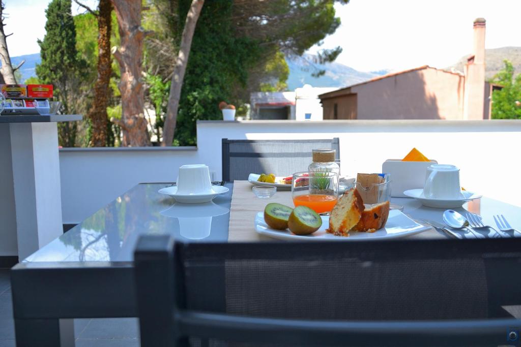 a table with a plate of food on a balcony at B&b Mondello Resort in Palermo