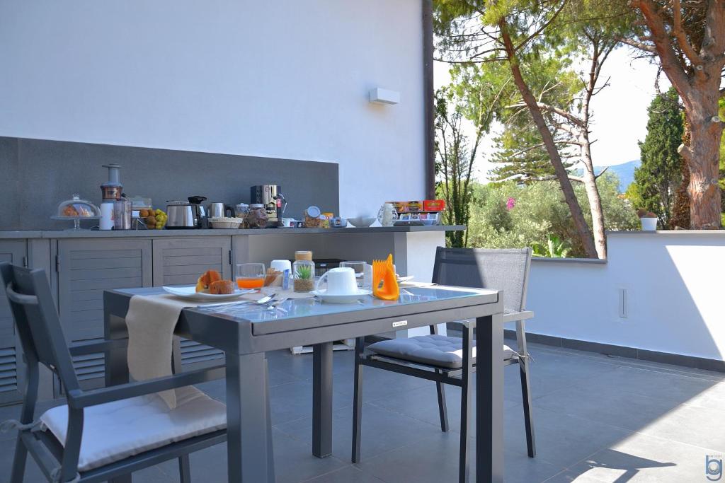 a table and chairs in a kitchen with a table and a window at B&b Mondello Resort in Palermo