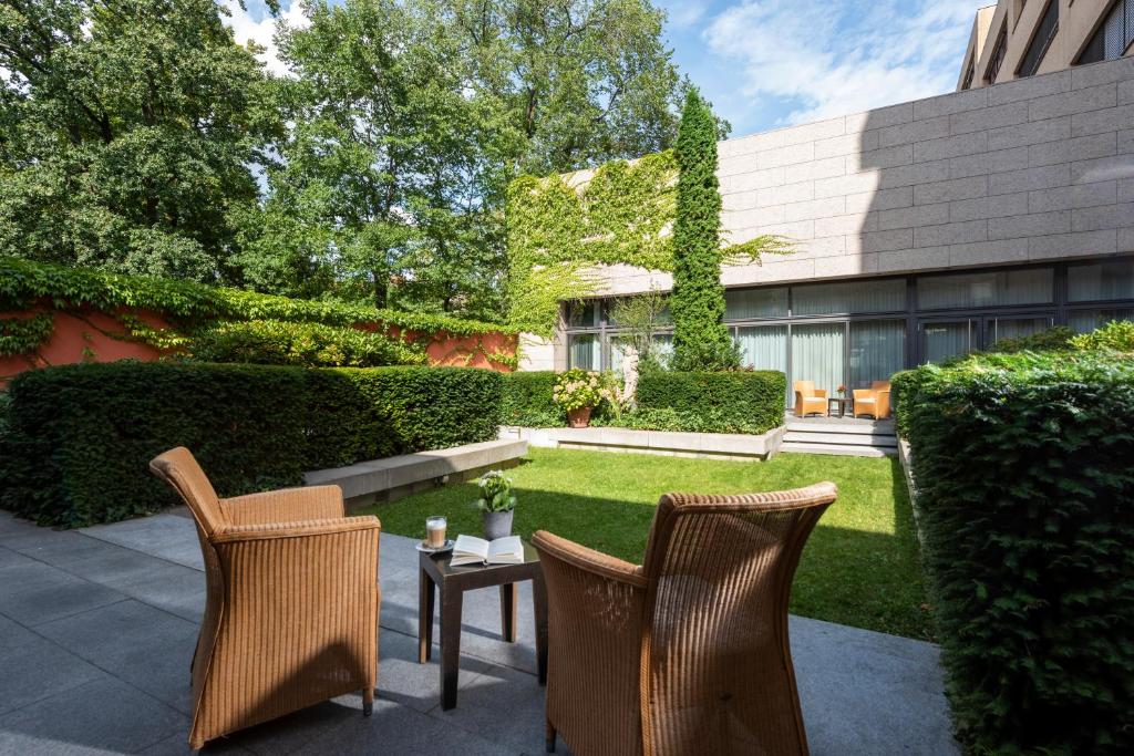 a patio with two chairs and a table in front of a building at Hotel Aquino Berlin in Berlin