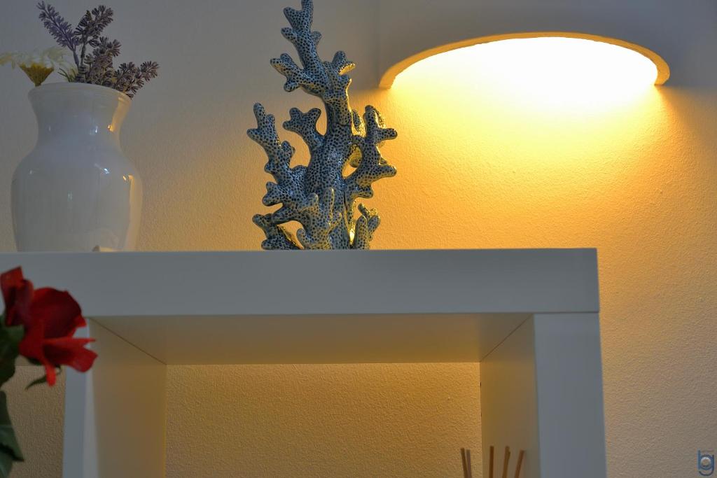a white table with a lamp and a vase on it at B&b Mondello Resort in Palermo