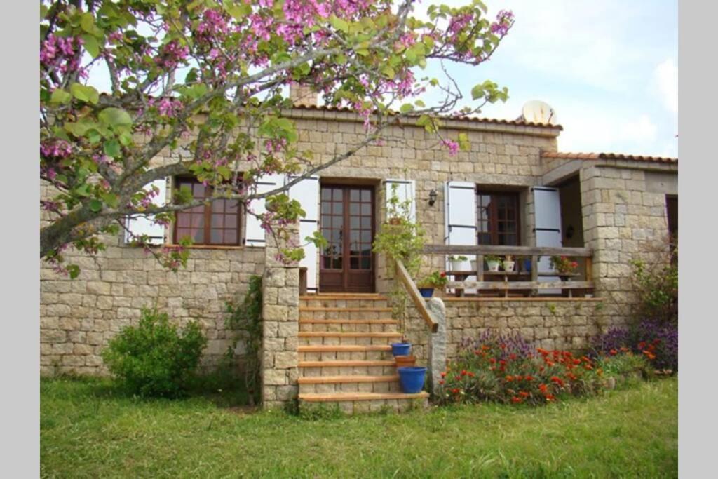 une maison en briques avec un escalier en face de celle-ci dans l'établissement Maison de charme proche mer en Corse du Sud, à Sollacaro