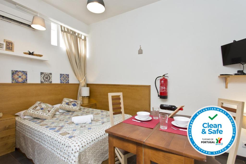 a room with a bed and a table with a sign at Host Wise - Cozy Quiet Flat - Trindade Station in Porto