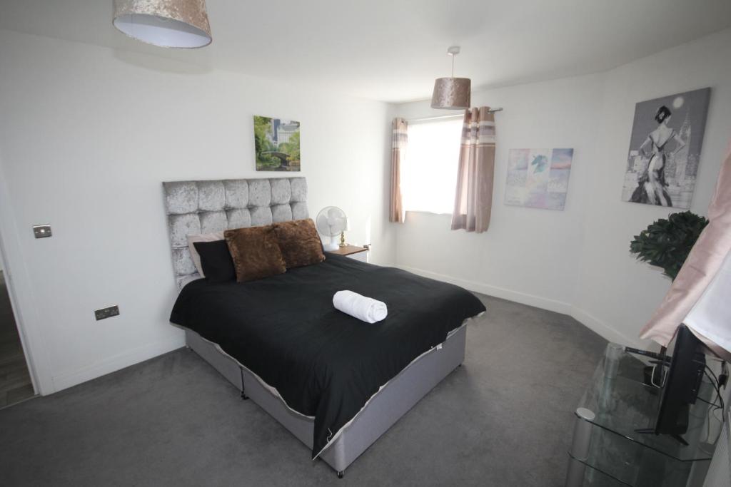 um quarto com uma cama grande num quarto branco em Holden Court Apartment - Apt 1 em West Drayton