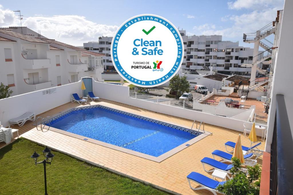 a white swimming pool with a blue sky at Apartamentos Carruna in Albufeira