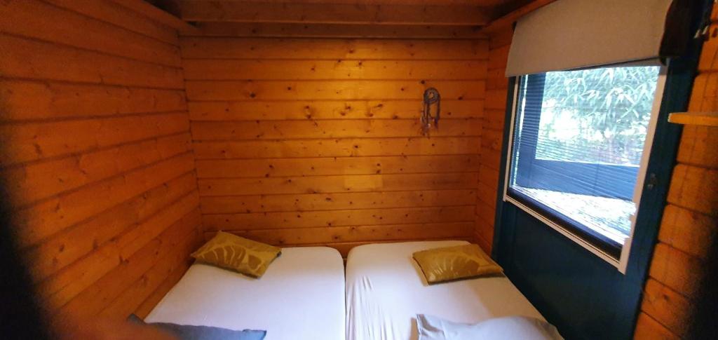 a small room with two beds in a log cabin at Chalet in paradise garden in Velden