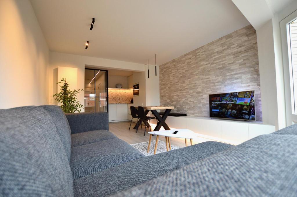 sala de estar con sofá y mesa en Ruim en lichtrijk appartement op 100m van zee te Koksijde en Koksijde