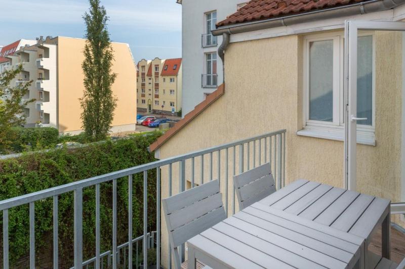 a white bench sitting on the balcony of a building at H&H Apartments im Herzen der Stadt in der Lange Strasse geräumig ruhig mit Küche und Esstisch in Greifswald