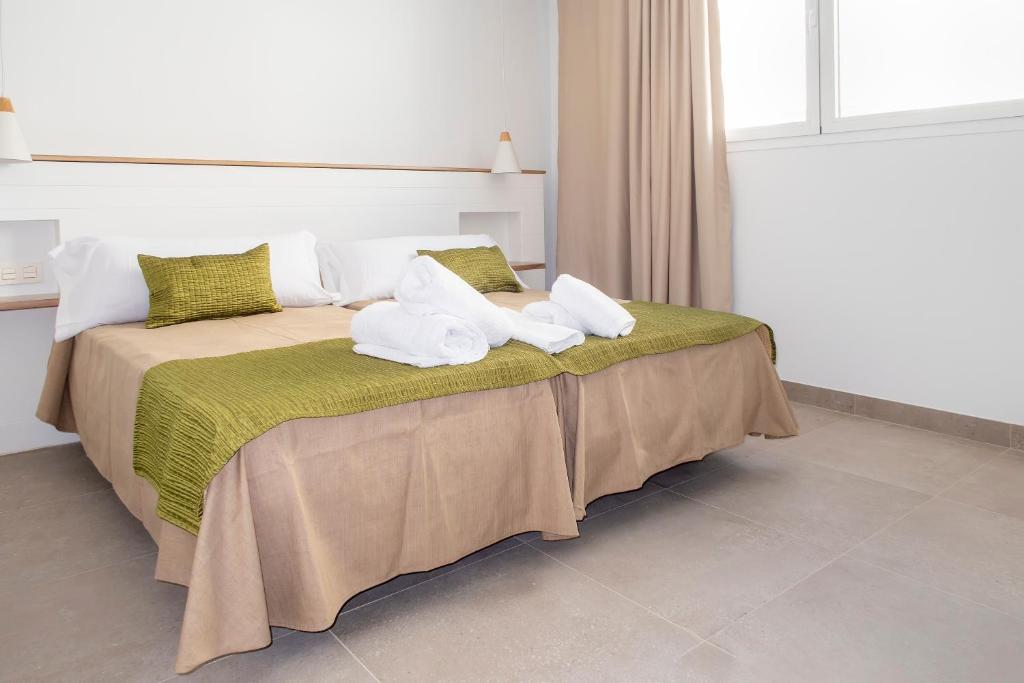 a bedroom with a bed with towels on it at Hotel Senderos in Agua Amarga