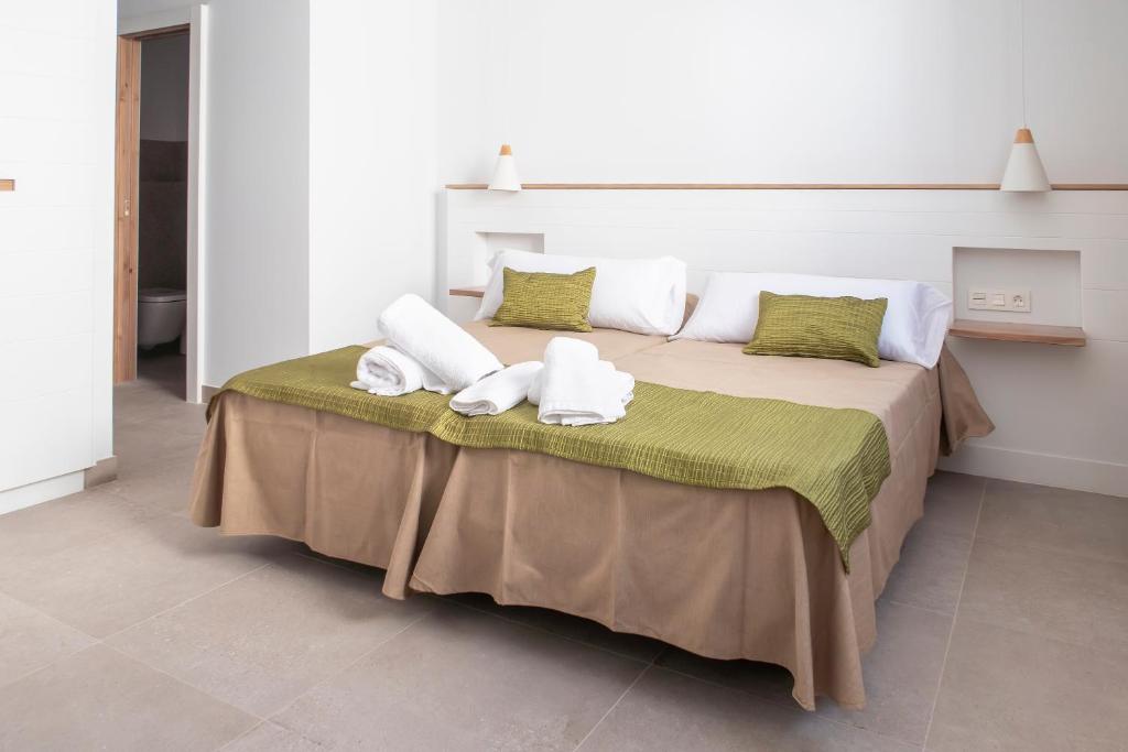 a bedroom with a bed with towels on it at Hotel Senderos in Agua Amarga