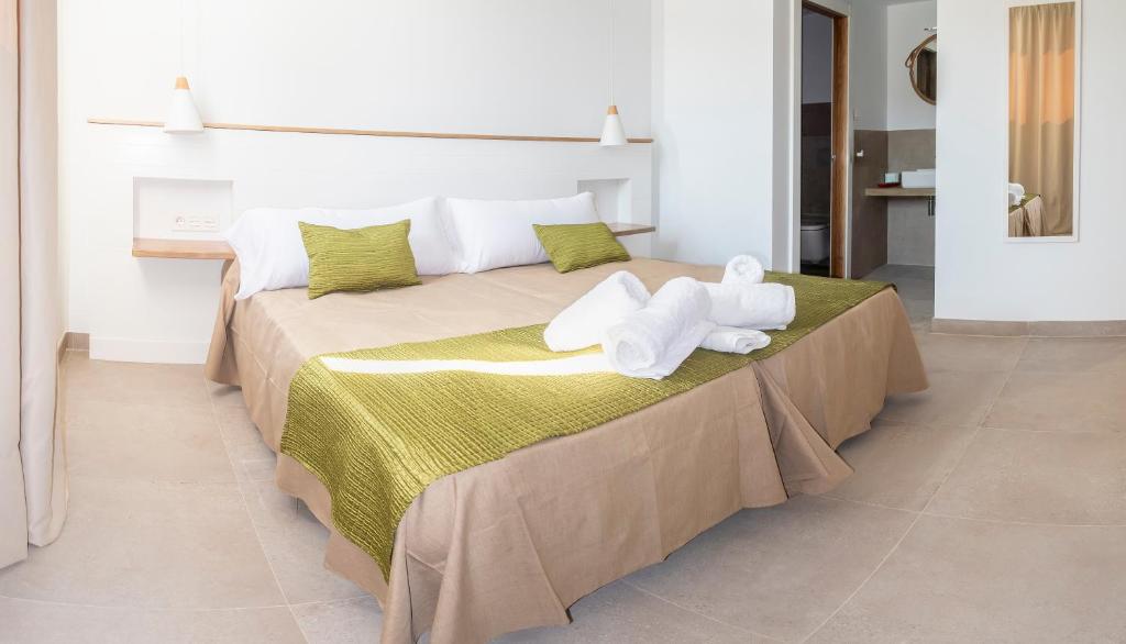 a bedroom with a large bed with towels on it at Hotel Senderos in Agua Amarga