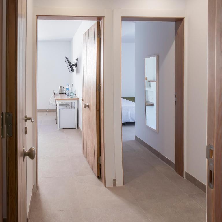 a room with a hallway with a bed and a mirror at Hotel Senderos in Agua Amarga