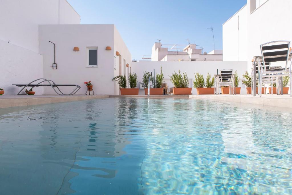 a swimming pool with blue water in a building at Hotel Senderos in Agua Amarga