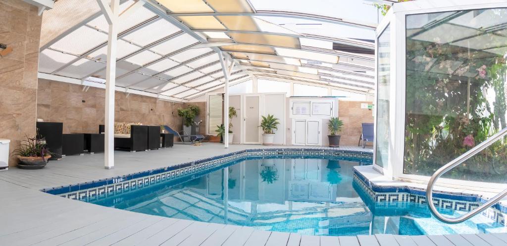 an indoor swimming pool with a glass ceiling at Hotel Senderos in Agua Amarga