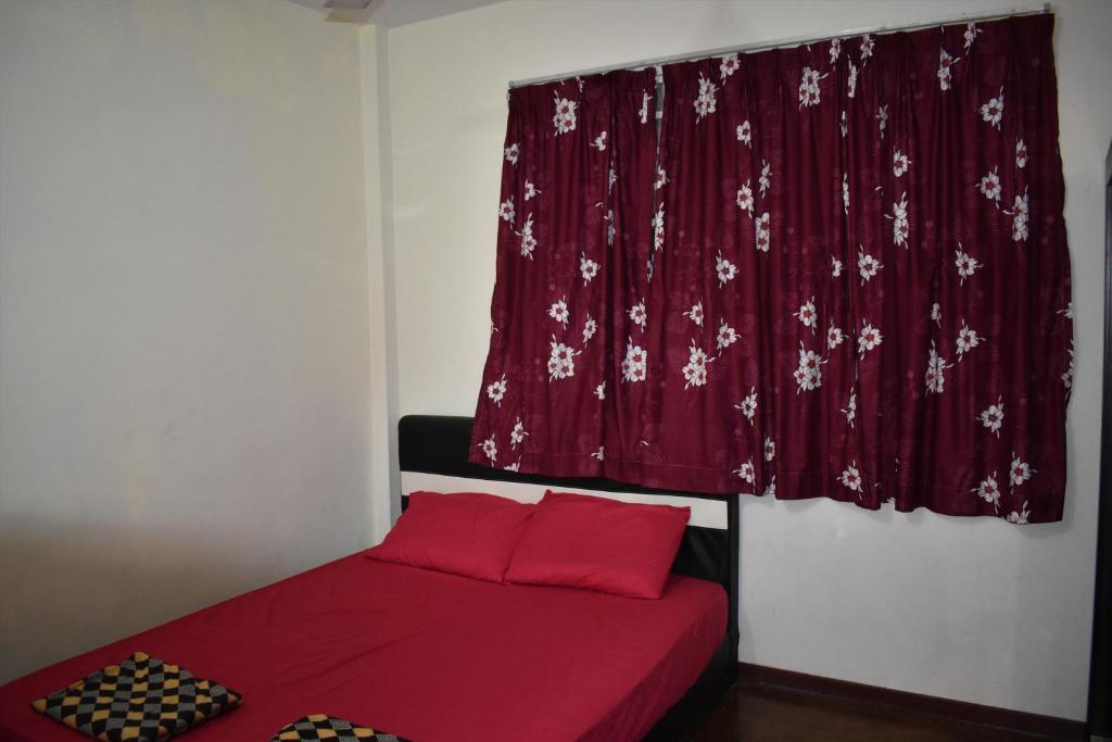 a bedroom with a red bed with a red curtain at PD Ohana Holiday home at Cocobay Resort PortDickson in Port Dickson