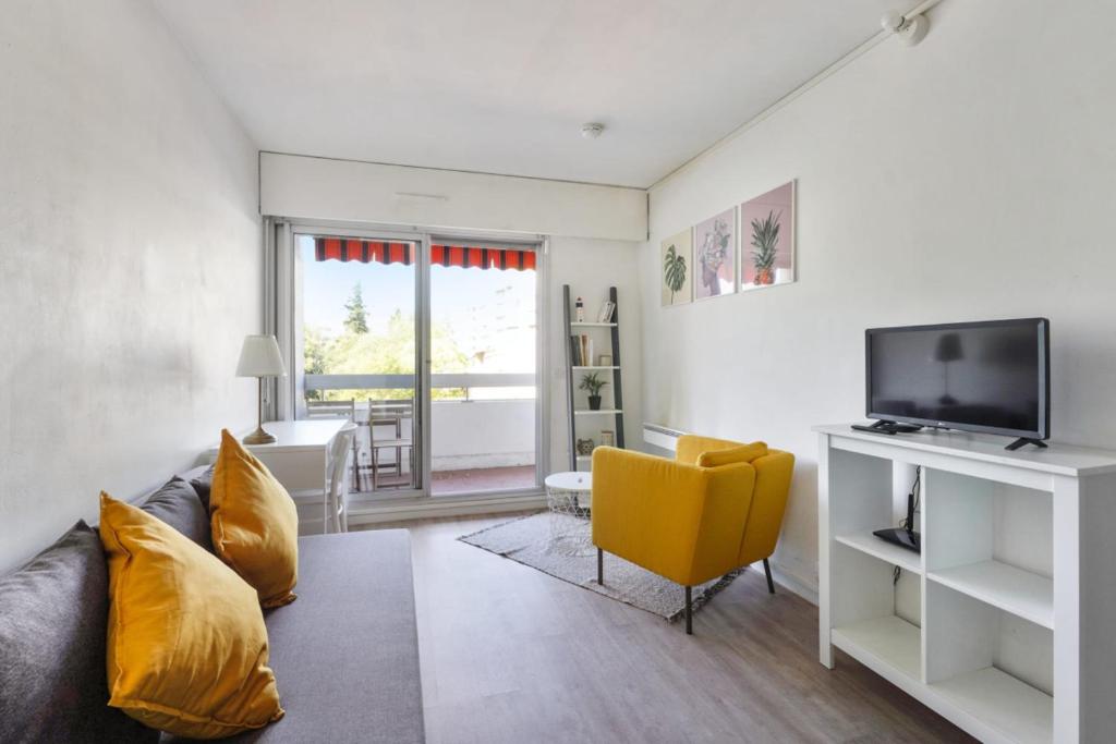 a living room with a couch and a television at Studio with terrace close to the Prado beach in Marseille Welkeys in Marseille