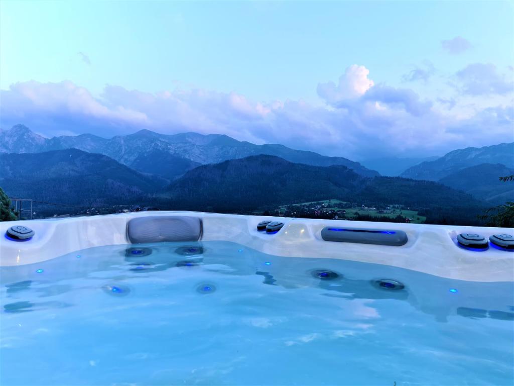a swimming pool with mountains in the background at Apartament Siwy Wierch in Kościelisko