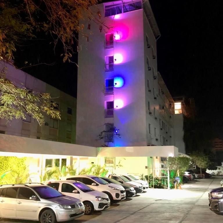 a building with cars parked in front of a building with purple lights at Hotel Appel in Santa Maria