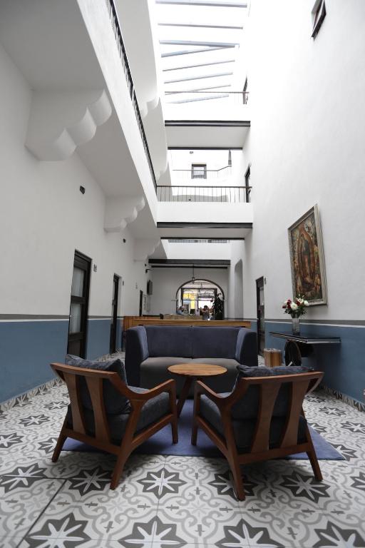 a lobby with a couch and chairs and a table at Hotel Sofia in Puebla