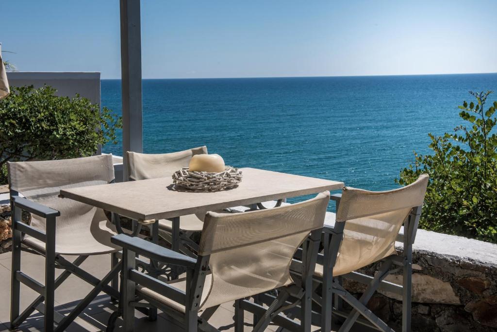 a table and chairs with the ocean in the background at Skajado Holiday Apartments in Stalís