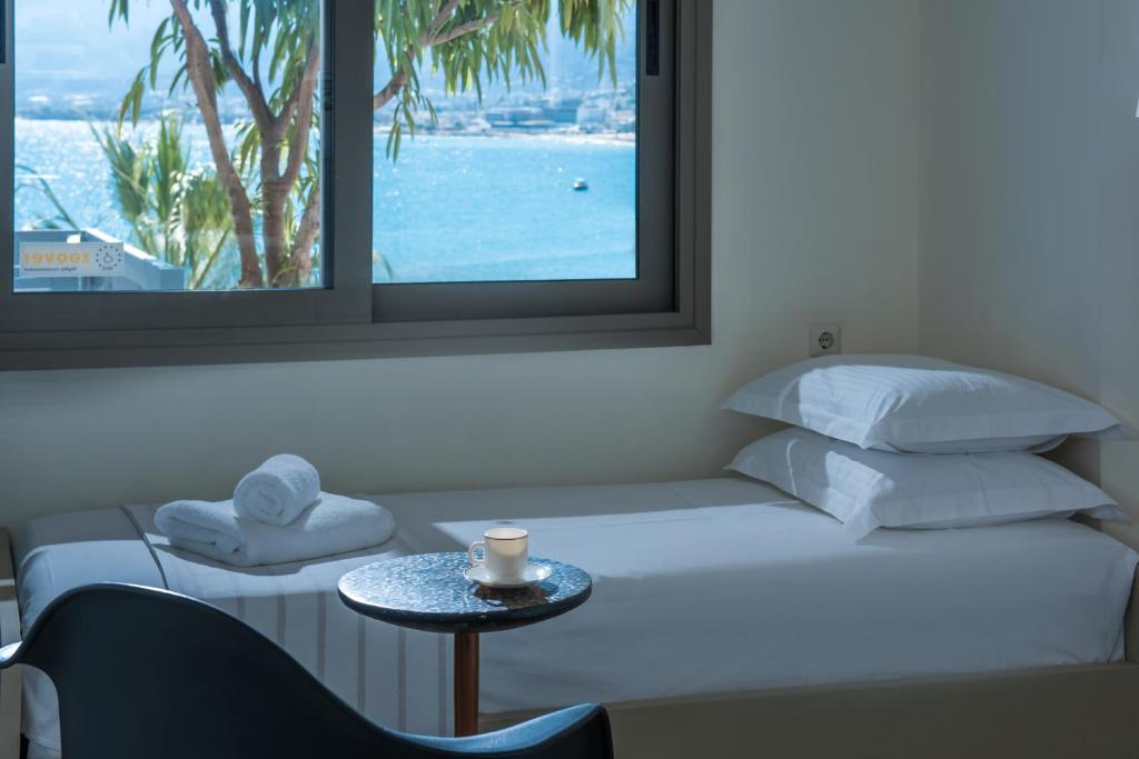 a bedroom with a bed with a table and a window at Skajado Holiday Apartments in Stalís