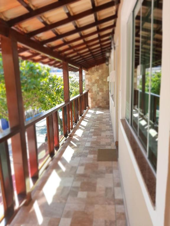 a hallway of a house with windows and a porch at Varandas do Atalaia Suítes in Arraial do Cabo