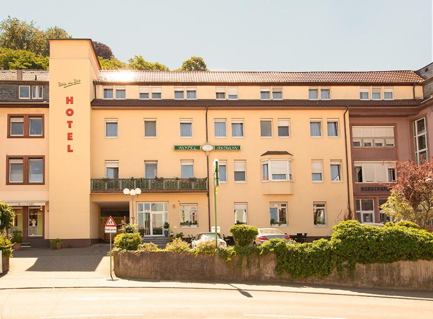 a tan building with a sign on the front of it at Hotel Avalon in Landstuhl