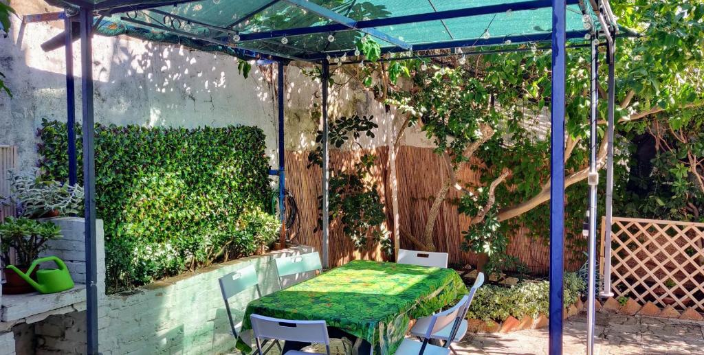 a pergola with a table and chairs in a garden at La casa di Ulisse in Gaeta