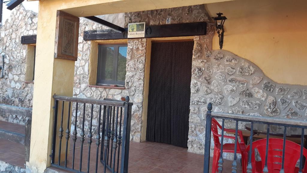 eine Tür zu einem Steingebäude mit einem Tisch und Stühlen in der Unterkunft Ventorrillo Cabaña 1 in Riópar