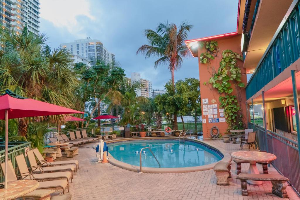 una piscina en un complejo con mesas y sillas en Ft. Lauderdale Beach Resort Hotel en Fort Lauderdale